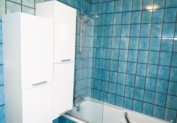 Une SDB avec une grande baignoire vitrée et de nombreux rangements
